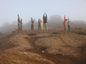 Alunos do Curso de Trekking fazendo yoga matinal no local do curso